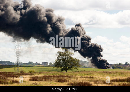Un incendie en milieu rural dans un domaine produisant un grand panache de fumée noire épaisse, Glasgow, Écosse, Royaume-Uni Banque D'Images
