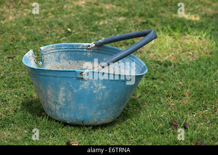 Un seau en métal bleu dans un champ d'herbe sur une ferme à Cotacachi (Équateur) Banque D'Images