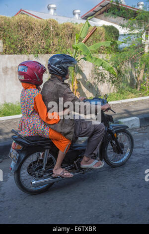 Yogyakarta, Indonésie. En moto, le trafic de la rue. Deux coureurs avec des casques. Banque D'Images