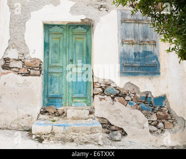 Vieille porte en bois d'une façade de maison demaged minable avant ou en bleu, vert et turquoise. Banque D'Images