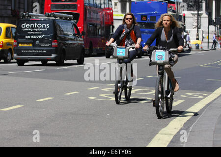 Deux femmes cyclistes équitation le long d'une route à Londres Banque D'Images