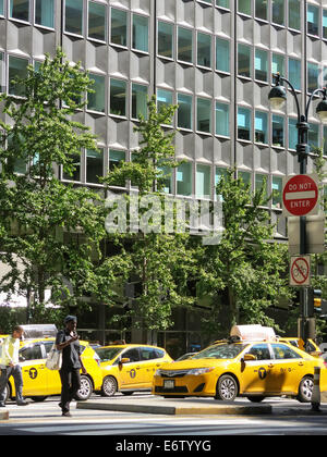 Woman Crossing Street en face de nombreux taxis, New York, USA Banque D'Images