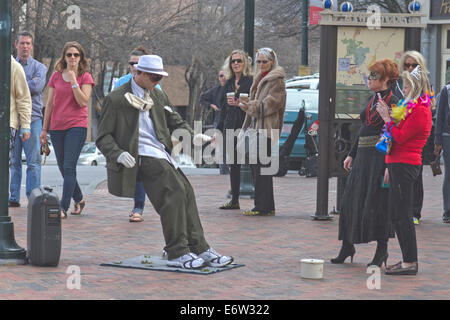 Asheville, Caroline du Nord, USA - 2 mars, 2014 : artiste de rue, statue vivante montrant un homme en costume d'être poussé vers l'arrière Banque D'Images