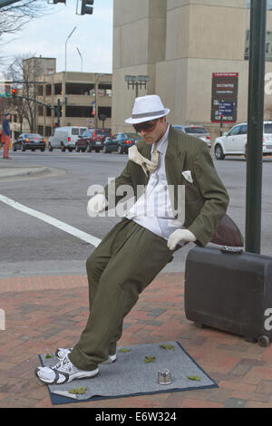 Asheville, Caroline du Nord, USA - 2 mars, 2014 : artiste de rue, statue vivante montrant un homme en costume d'être poussé vers l'arrière Banque D'Images