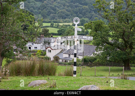 Un vieux panneau routier avec Buttermere village dans l'arrière-plan Banque D'Images