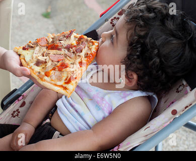 Dame rss Tranche de pizza à un an, fille, dans la PRAM. Bogota Colombie. Banque D'Images