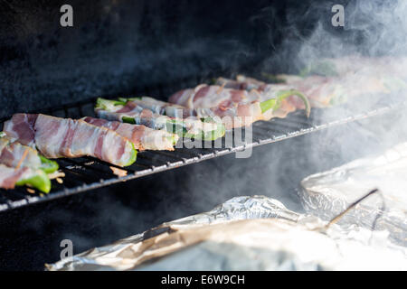 L'asperge enrobé de bacon sur la grille du barbecue. Banque D'Images