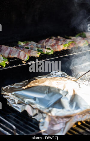 L'asperge enrobé de bacon sur la grille du barbecue. Banque D'Images
