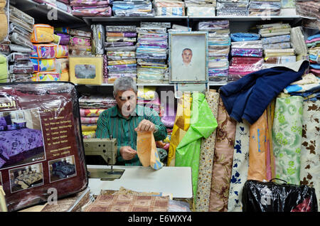 Homme coud dans bazar arabe dans la vieille ville, Jérusalem, Israël Banque D'Images