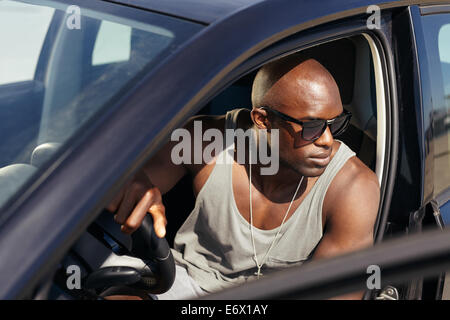 Image de jeune homme dans la voiture à la route. L'Afrique de l'élégant guy on road trip. Banque D'Images