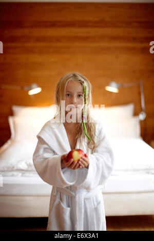 Jeune fille dans une chambre double à l'hôtel Haus Hirt, tenant une pomme, Bad Gastein, St Johann im Pongau, Salzbourg, Autriche Banque D'Images