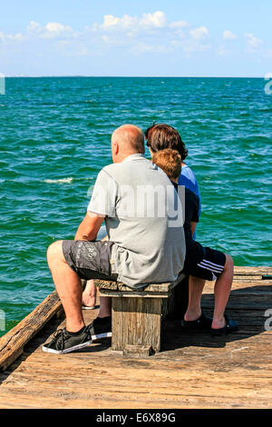 Un groupe de la famille s'asseoir sur une banquette à regarder les eaux d'Anna Maria Pier à Bradenton FL Banque D'Images