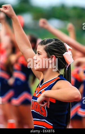 Junior Varsity High School cheerleader femelle, devant une foule prête à rah rah ! Banque D'Images