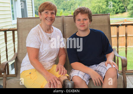 Grand-mère avec une prothèse de jambe avec son petit-fils assis sur leur terrasse extérieure Banque D'Images