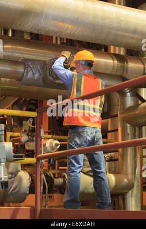 Ingénieur dans l'usine d'énergie électrique vanne manuelle de réglage dans le condenseur tuyauterie chambre Banque D'Images