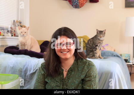 Femme avec le syndrome d'Asperger de jouer avec ses chats pet Banque D'Images