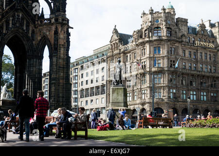 Les gens dans les jardins de Princes Street à côté du Scott Monument à Jenners department store à l'arrière-plan, Édimbourg Banque D'Images