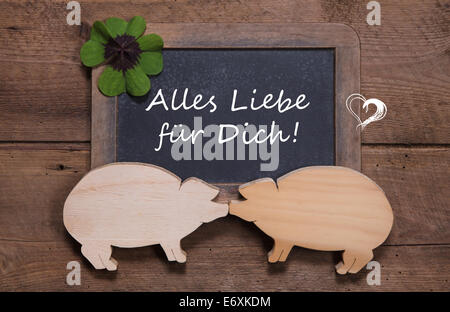 Carte de souhaits avec clover et deux cochons en bois - comme dans un couple - chance pour le jour de l'an, la saint valentin ou anniversaire - l'amour - sur Banque D'Images