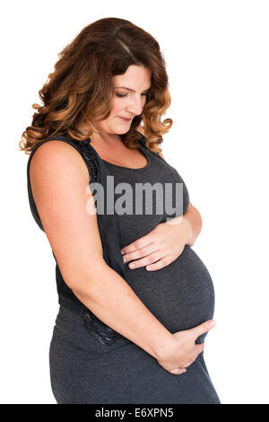 Pregnant woman holding ses mains sur son ventre Banque D'Images