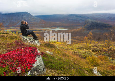 En regardant l'homme avec des jumelles à sarek national park et du paysage sont en couleurs d'automne Banque D'Images