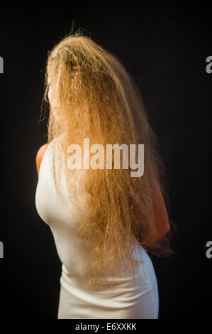 Une jeune femme aux longs cheveux blonds blonde vêtue d'une robe blanche Banque D'Images