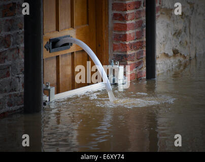 Rivière eau pompée hors de la maison inondée Banque D'Images