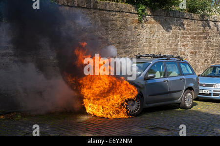 Un dimanche matin tranquille dans une rue résidentielle à Édimbourg, un véhicule à moteur prend feu, probablement en raison d'un défaut électrique. Banque D'Images