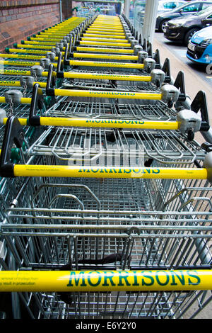 Une ligne de chariots à l'extérieur d'un supermarché Morrisons à Oswestry, Shropshire, Angleterre. Banque D'Images