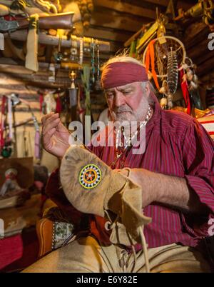 Erfurt, Allemagne. 22 août, 2014. Guentherodt Falk trappeur mocassins réparations à Erfurt, Allemagne, 22 août 2014. Il exploite son propre Zoo Indianercamp Erfurt (Native American Camp), où il a également vécu pendant de nombreuses années. Photo : MICHAEL REICHEL/dpa/Alamy Live News Banque D'Images