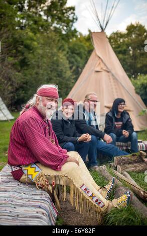 Erfurt, Allemagne. 22 août, 2014. Guentherodt trappeur Falk (L) est assis autour d'un feu à Erfurt, Allemagne, 22 août 2014. Il exploite son propre Zoo Indianercamp Erfurt (Native American Camp), où il a également vécu pendant de nombreuses années. Photo : MICHAEL REICHEL/dpa/Alamy Live News Banque D'Images