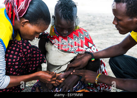 Une équipe de vaccination mobile visite un petit village Turkana par le lac Turkana et vaccine les nourrissons et les petits bébés. Banque D'Images