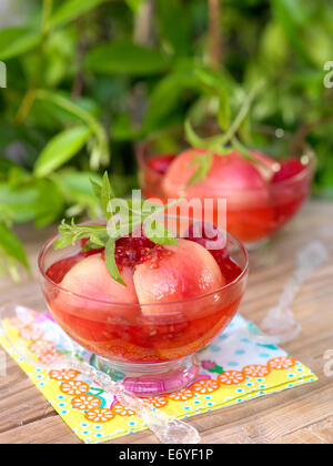 Compote de framboises et de pêches au vin blanc Banque D'Images