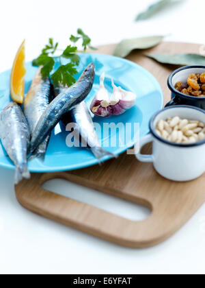 Ingrédients pour les sardines farcies aux pignons de pin, les raisins secs, les feuilles de laurier et sauce à l'orange Banque D'Images