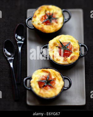 Tomate cerise et fromage de chèvre puddings salés Banque D'Images