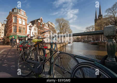 AMSTERDAM, Pays-Bas - 19 mars 2014 : maisons colorées sur le canal au printemps journée ensoleillée. Stand des vélos garés sur le pont Banque D'Images