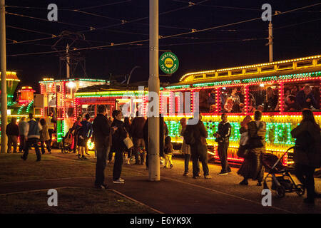 Des gens font la queue pour des trolleybus à Blackpool, Lancashire, Royaume-Uni. 1er septembre 2014. Les passagers font la queue pour monter à bord du trolleybus illuminé du train occidental à Blackpool Lights 2014. Le département des illuminations de Blackpool a remis à neuf le Tram Rocket. Ce tramway a été en service pour la dernière fois en 1999 et construit en 1961. Il a été construit à l'origine sur un châssis de tramway standard et l'habitacle s'est incliné comme si le Rocket grimpait en altitude. Banque D'Images