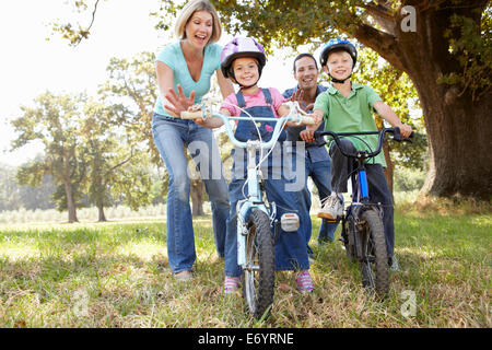 Les parents de jeunes enfants sur des vélos Banque D'Images