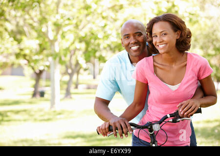 Jeune couple cycling in park Banque D'Images