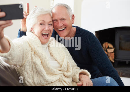 Senior Couple Sitting on Sofa prenant Selfies Banque D'Images