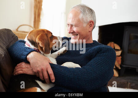 Senior Woman Relaxing At Home With Pet Dog Banque D'Images