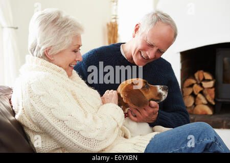 Senior Couple Relaxing At Home With Pet Dog Banque D'Images