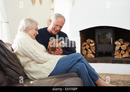 Senior Couple Relaxing At Home With Pet Dog Banque D'Images