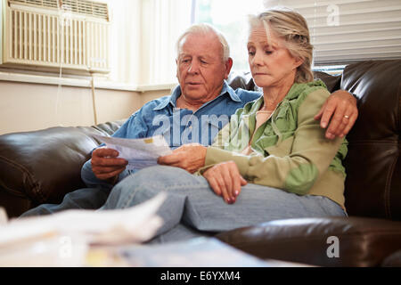 Inquiets Senior Couple Sitting on Sofa à la recherche sur les projets de Banque D'Images