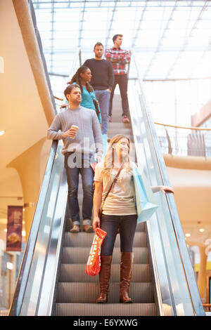 Femme Shopper sur Escalator dans Shopping Mall Banque D'Images