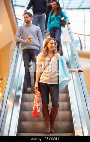 Femme Shopper sur Escalator dans Shopping Mall Banque D'Images