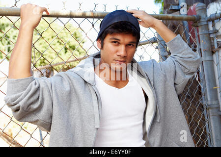 Portrait de jeune homme en milieu urbain pour Standing By Fence Banque D'Images