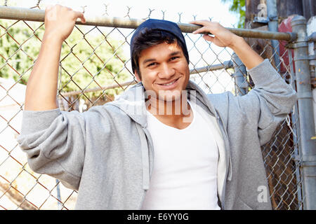 Portrait de jeune homme en milieu urbain pour Standing By Fence Banque D'Images