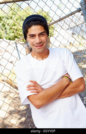 Portrait de jeune homme en milieu urbain pour Standing By Fence Banque D'Images