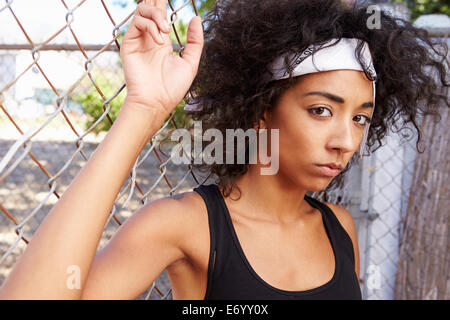 Portrait de jeune femme en milieu urbain pour Standing By Fence Banque D'Images