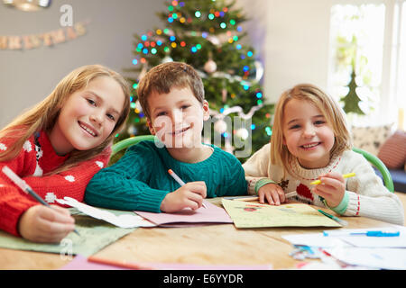 Trois enfants d'écrire des lettres au Père Noël ensemble Banque D'Images